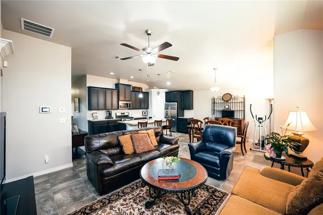 a living room with furniture kitchen view and a chandelier