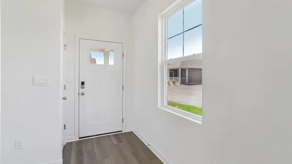 an entryway to room with wooden floor and windows
