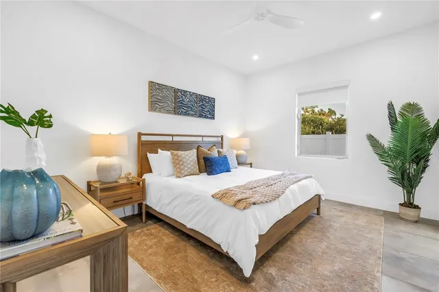 a view of swimming pool with red chairs in front of house