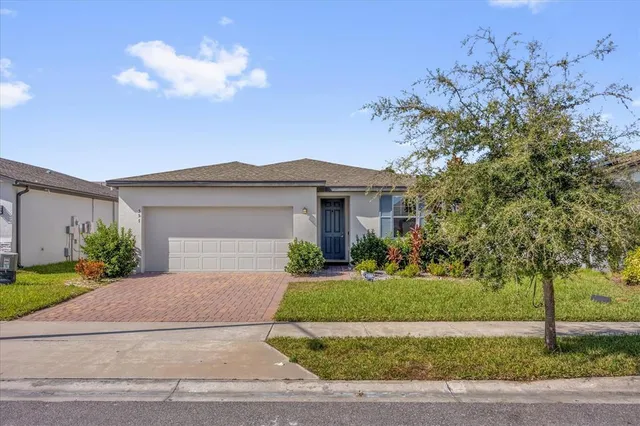 a front view of a house with a yard and a garage