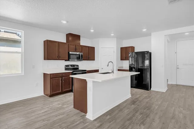 a kitchen with stainless steel appliances granite countertop a refrigerator stove and microwave