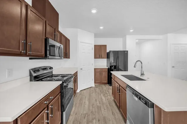 a kitchen with stainless steel appliances granite countertop a sink stove and refrigerator