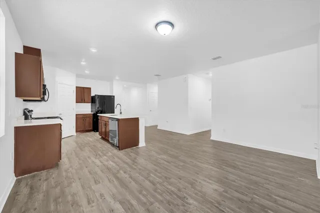 a view of a kitchen with wooden floor and electronic appliances