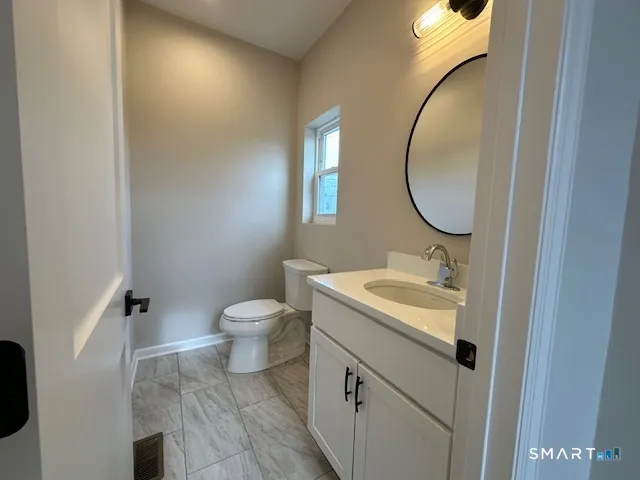 a bathroom with a toilet sink and mirror