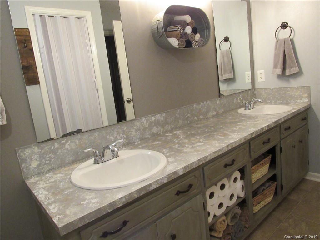 1226 Howards Creek Mill Road Vale, NC 28168 - Photo 11 of 22 a bathroom with a granite countertop sink and a mirror