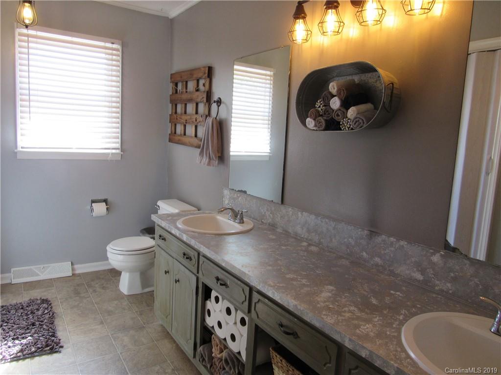 1226 Howards Creek Mill Road Vale, NC 28168 - Photo 12 of 22 a bathroom with a granite countertop toilet sink and mirror