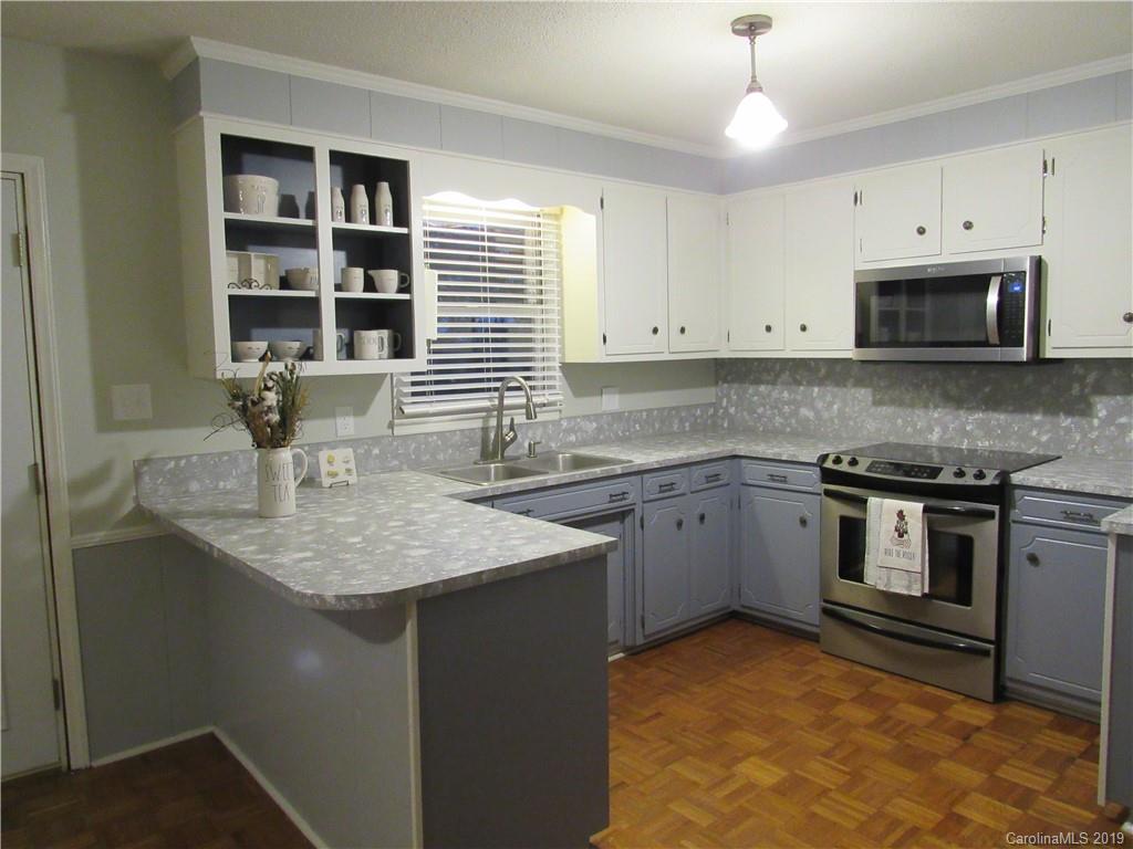 1226 Howards Creek Mill Road Vale, NC 28168 - Photo 8 of 22 a kitchen with stainless steel appliances granite countertop a sink a stove and white cabinets