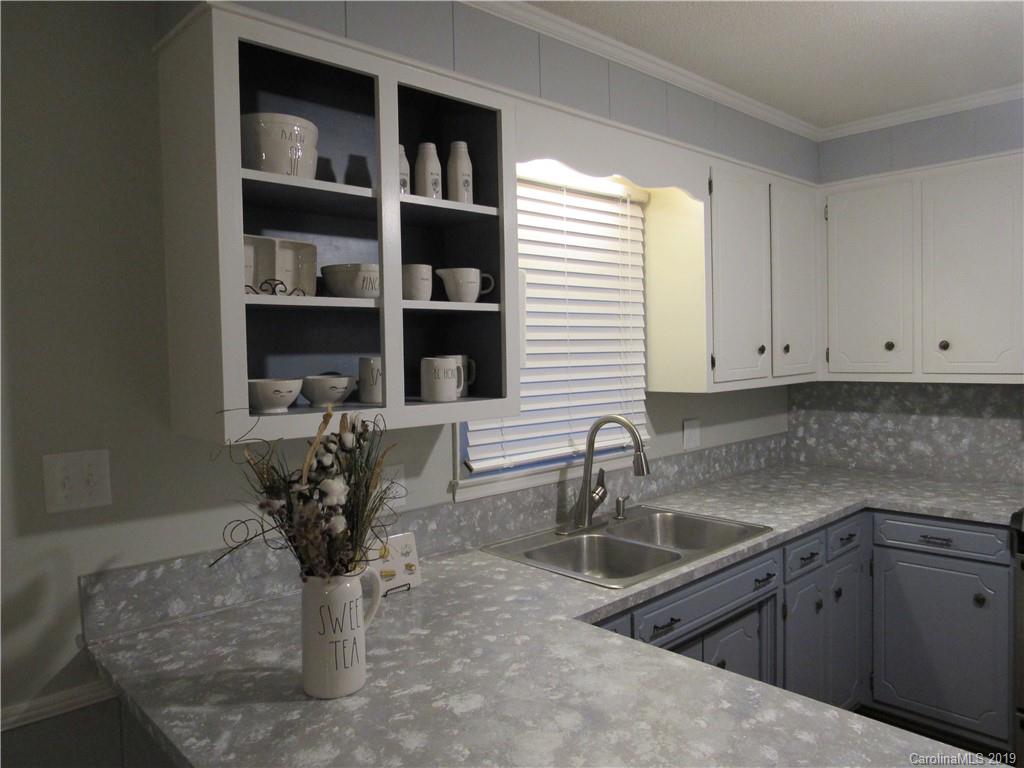 1226 Howards Creek Mill Road Vale, NC 28168 - Photo 9 of 22 a kitchen with granite countertop a sink a stove and a microwave