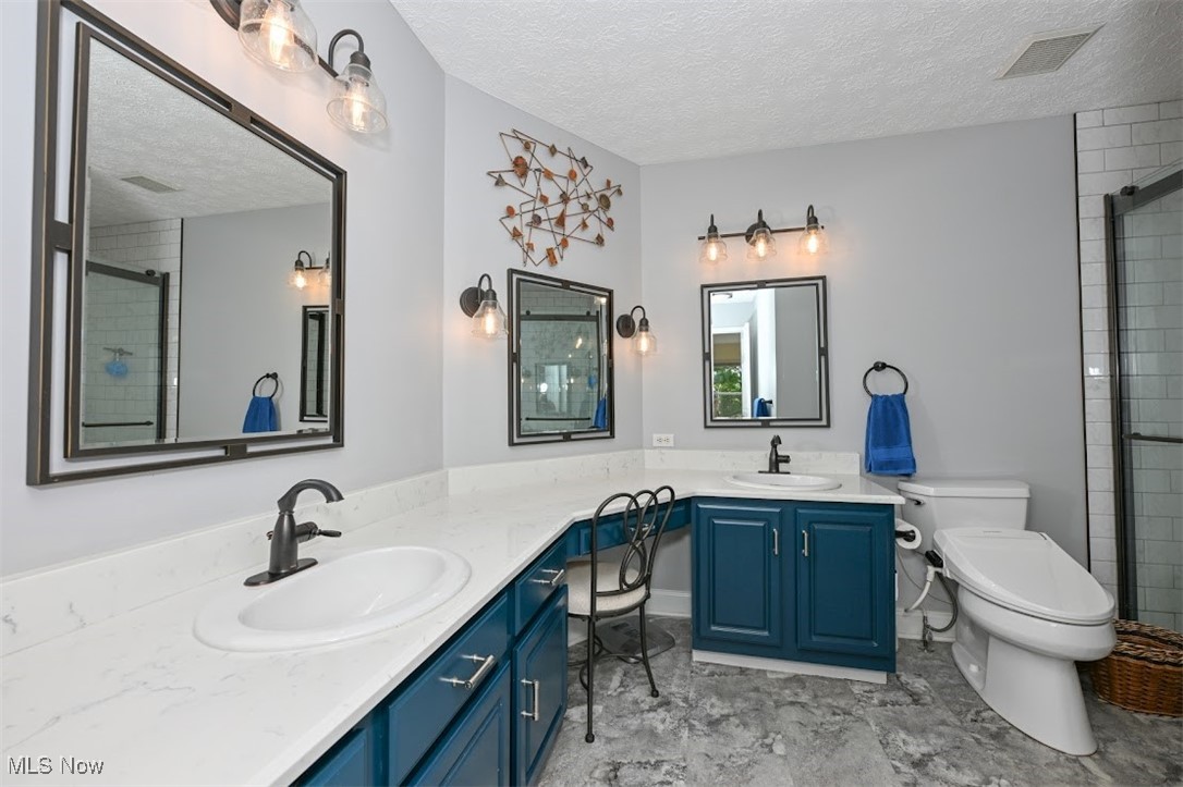4902 Foote Road, Unit 33 Medina, OH 44256 - Photo 17 of 46 Bathroom with vanity, toilet, walk in shower, and a textured ceiling