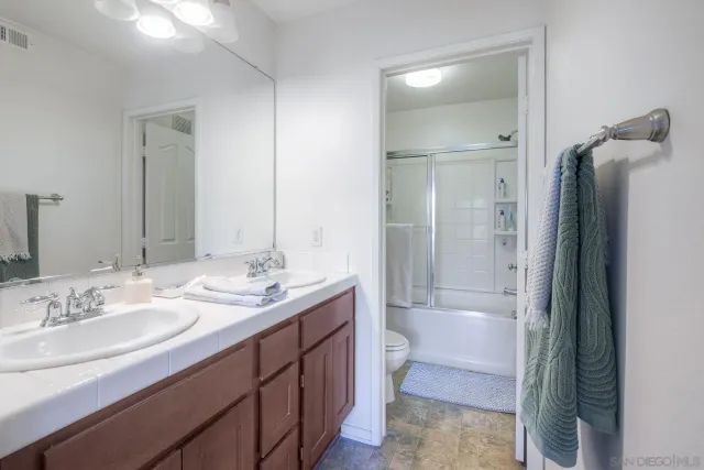 a bathroom with a granite countertop sink toilet and shower