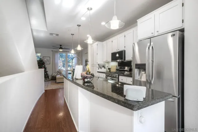 a kitchen with stainless steel appliances granite countertop a sink a stove and a refrigerator