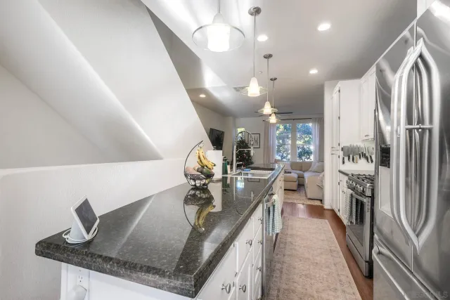 a kitchen with stainless steel appliances granite countertop a sink refrigerator and cabinets