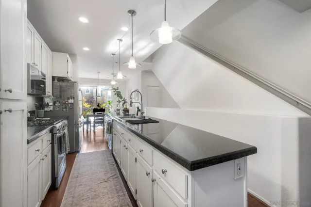 a kitchen with stainless steel appliances granite countertop a sink a stove and a refrigerator