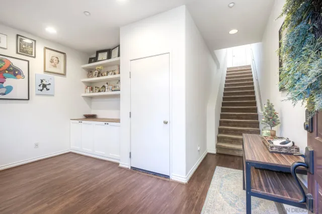 a view of a hallway with wooden floor and a workspace