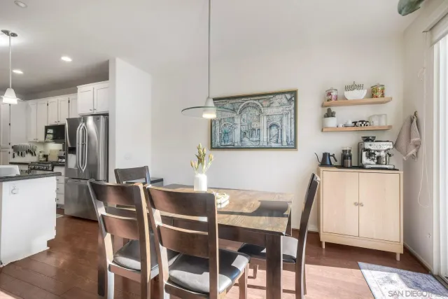 a dining room with stainless steel appliances kitchen island granite countertop furniture and a refrigerator