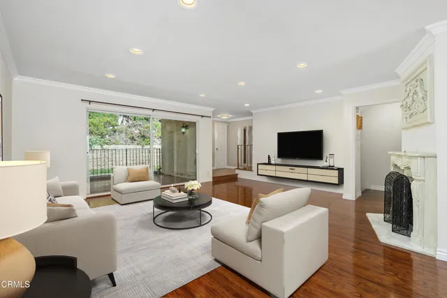 a living room with furniture a flat screen tv and a fireplace