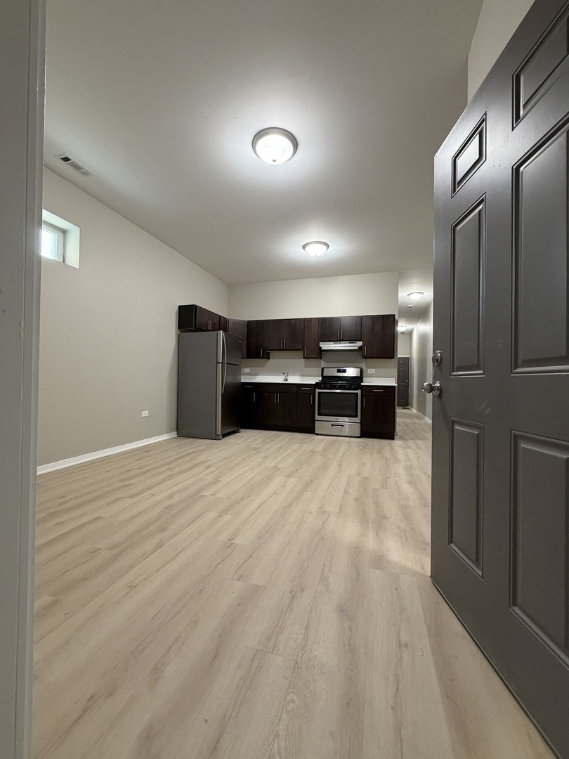 22 North Pulaski Road, Unit 1R Chicago, IL 60624 - Photo 7 of 22 a view of kitchen with refrigerator and furniture