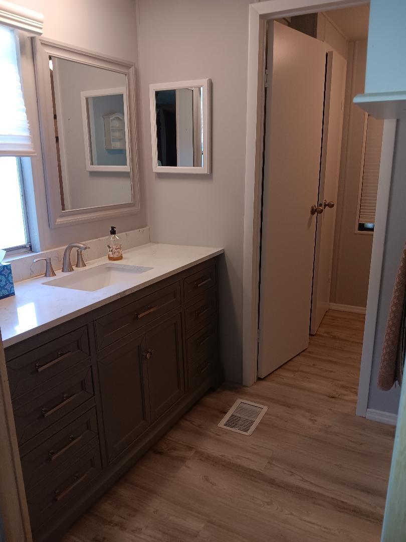 6985 Southeast Amendment Street Hobe Sound, FL 33455 - Photo 12 of 27 a bathroom with a double vanity sink and mirror