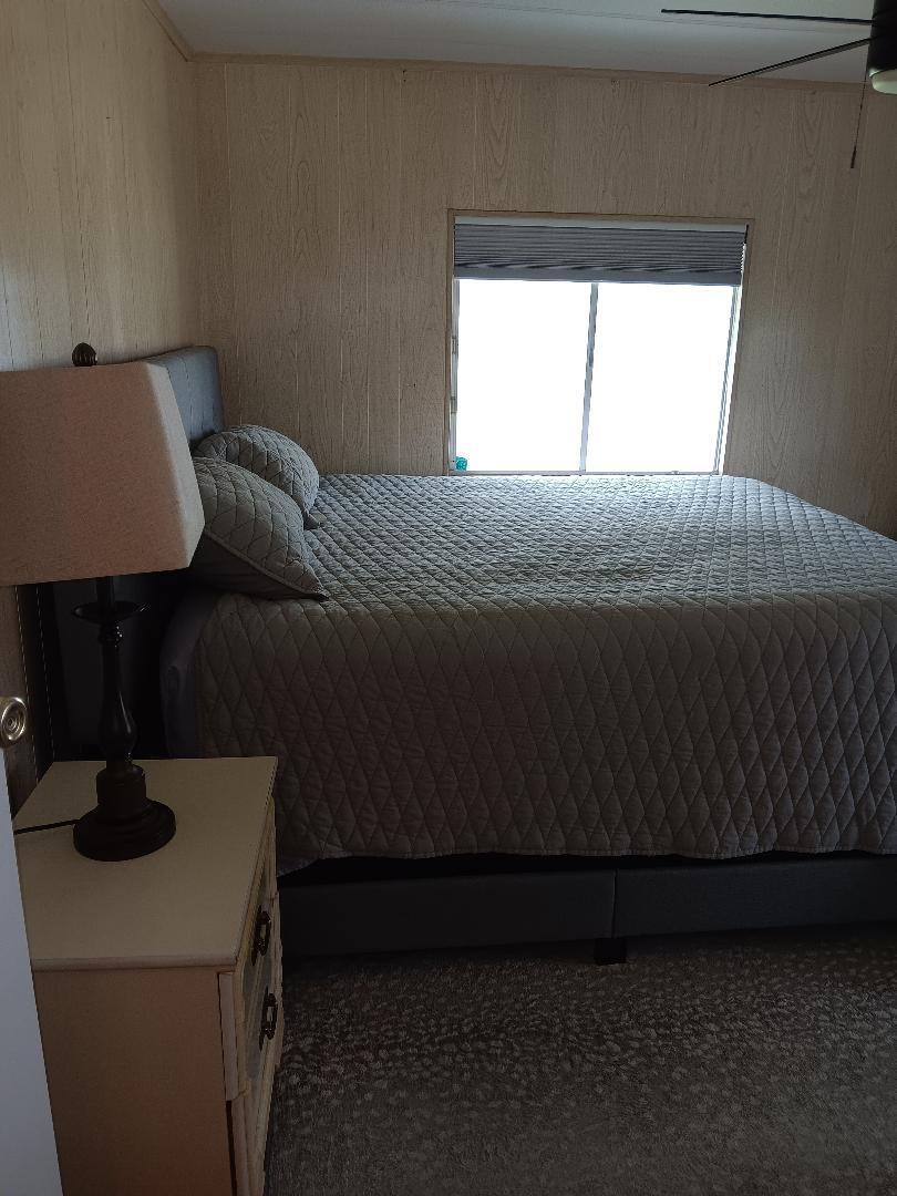 6985 Southeast Amendment Street Hobe Sound, FL 33455 - Photo 14 of 27 a bed sitting in a bedroom next to a window