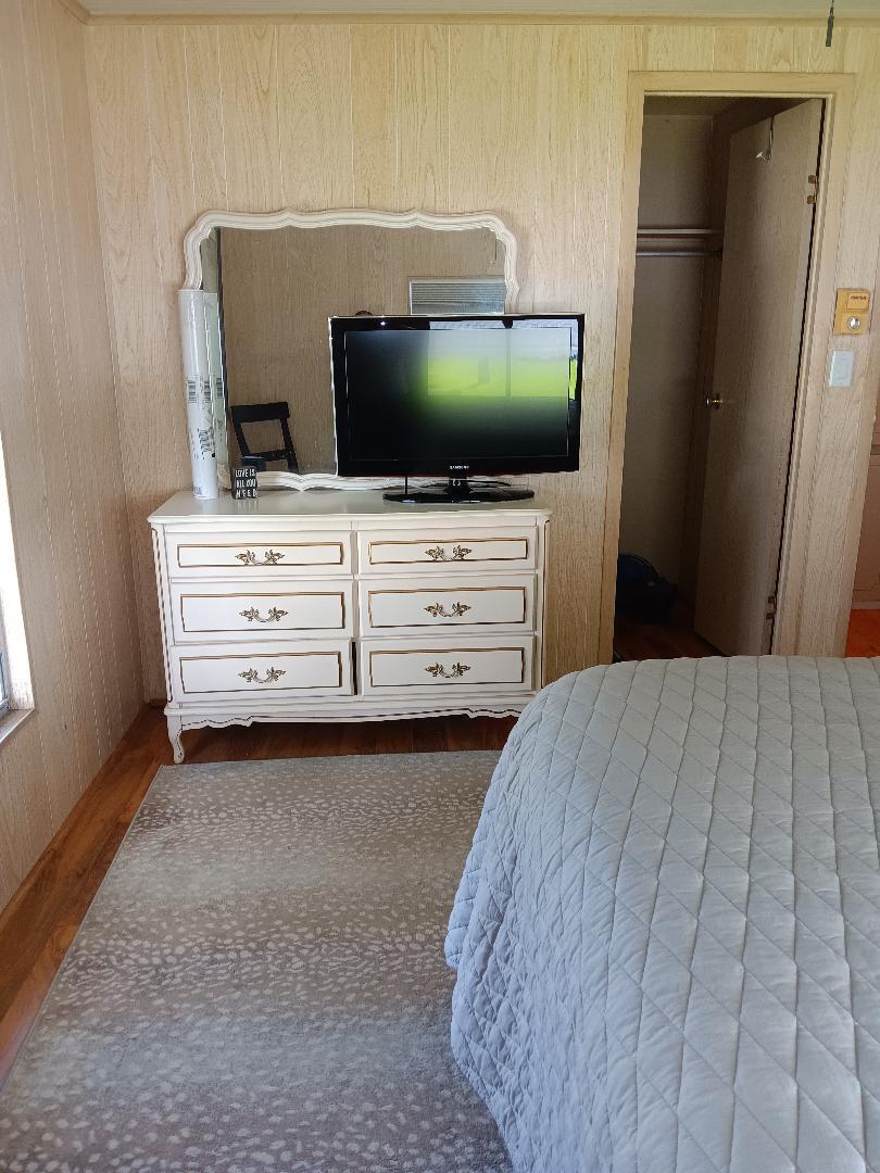 6985 Southeast Amendment Street Hobe Sound, FL 33455 - Photo 15 of 27 a bedroom with a bed and flat screen tv