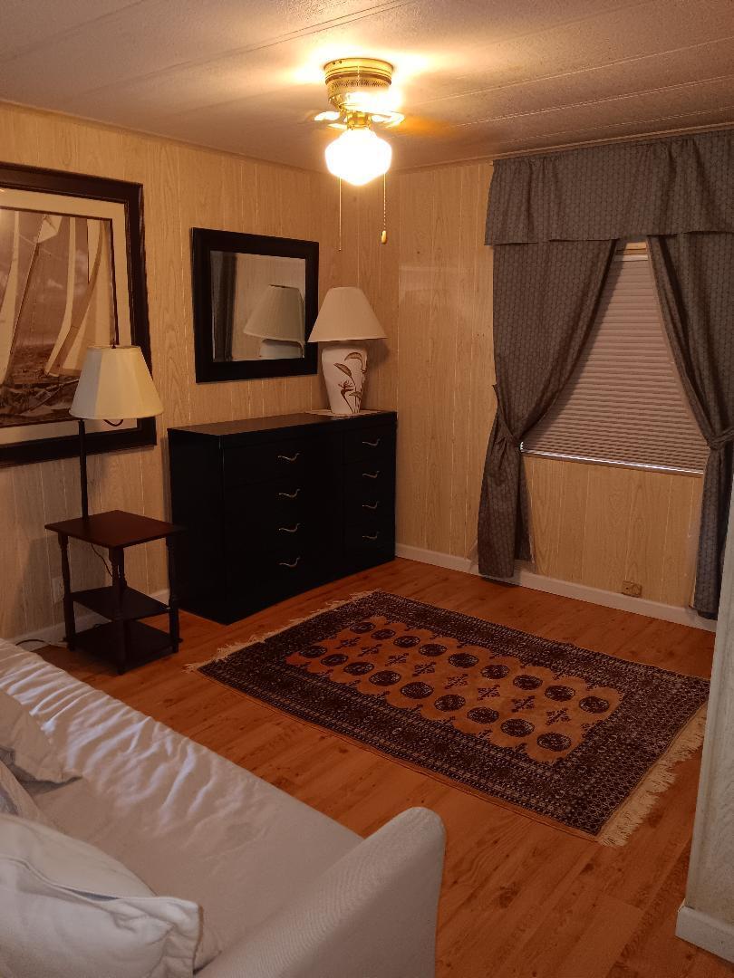 6985 Southeast Amendment Street Hobe Sound, FL 33455 - Photo 18 of 27 a bedroom with a bed and a dresser