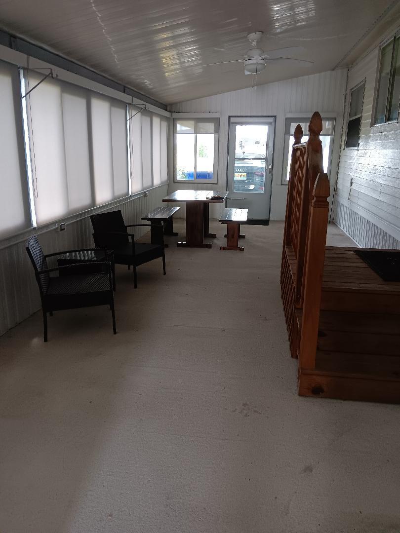 6985 Southeast Amendment Street Hobe Sound, FL 33455 - Photo 20 of 27 a living room with furniture a window and a projector