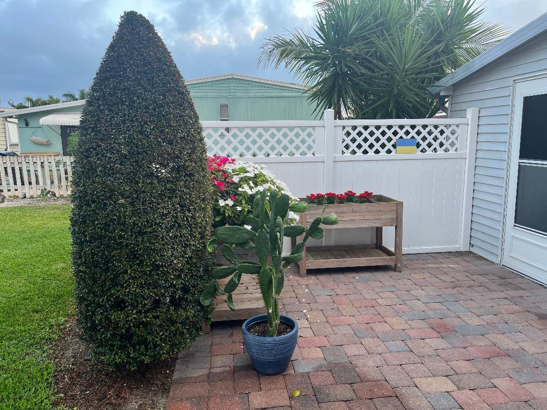 6985 Southeast Amendment Street Hobe Sound, FL 33455 - Photo 23 of 27 a potted plant sitting in front of a house