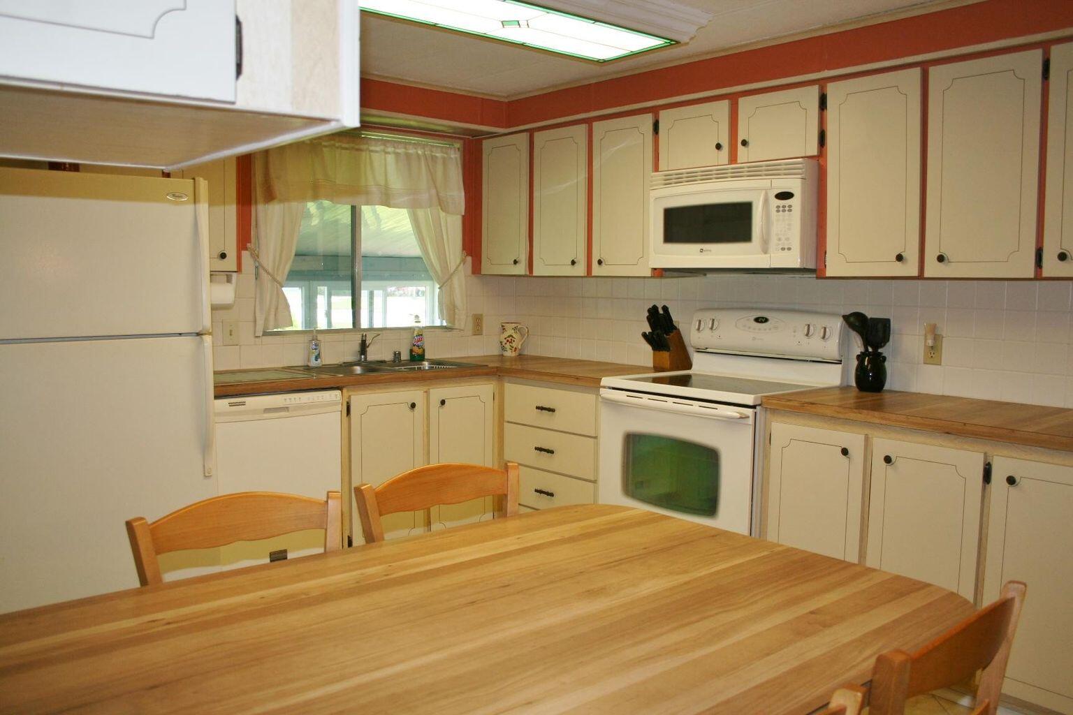 6985 Southeast Amendment Street Hobe Sound, FL 33455 - Photo 4 of 27 a kitchen with a sink a stove and white cabinets