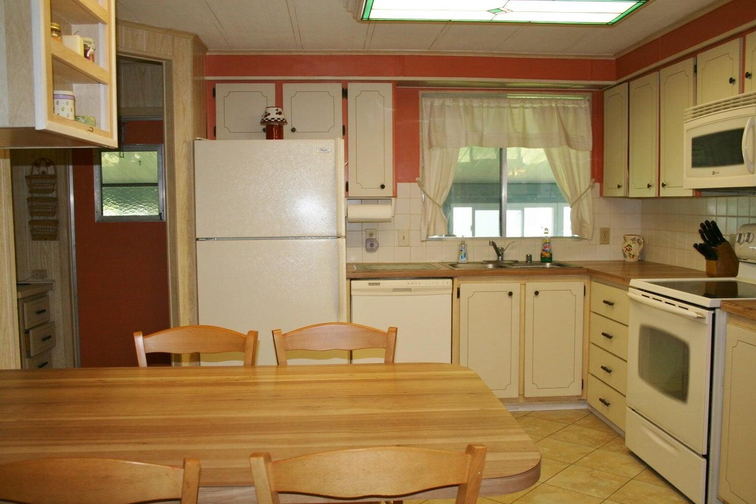 6985 Southeast Amendment Street Hobe Sound, FL 33455 - Photo 5 of 27 a kitchen with stainless steel appliances granite countertop a stove a sink and a refrigerator