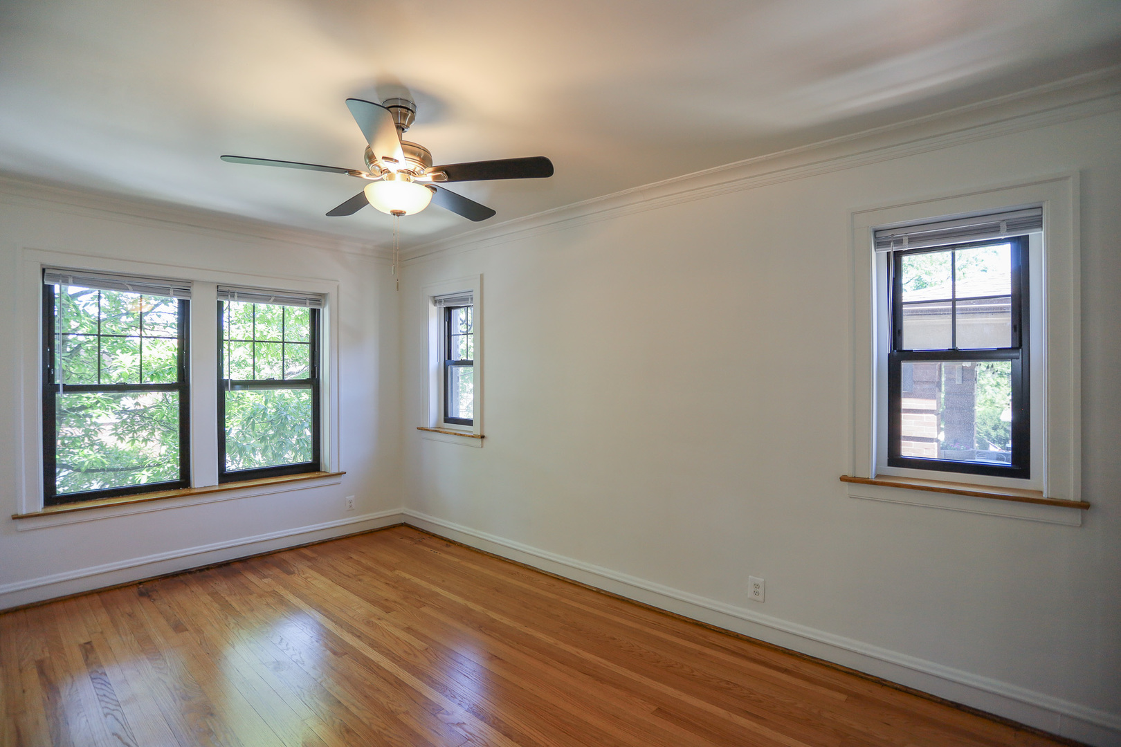 4411 North Hamilton Avenue, Unit 2W Chicago, IL 60618 - Photo 2 of 15 a view of an empty room with wooden floor and a window
