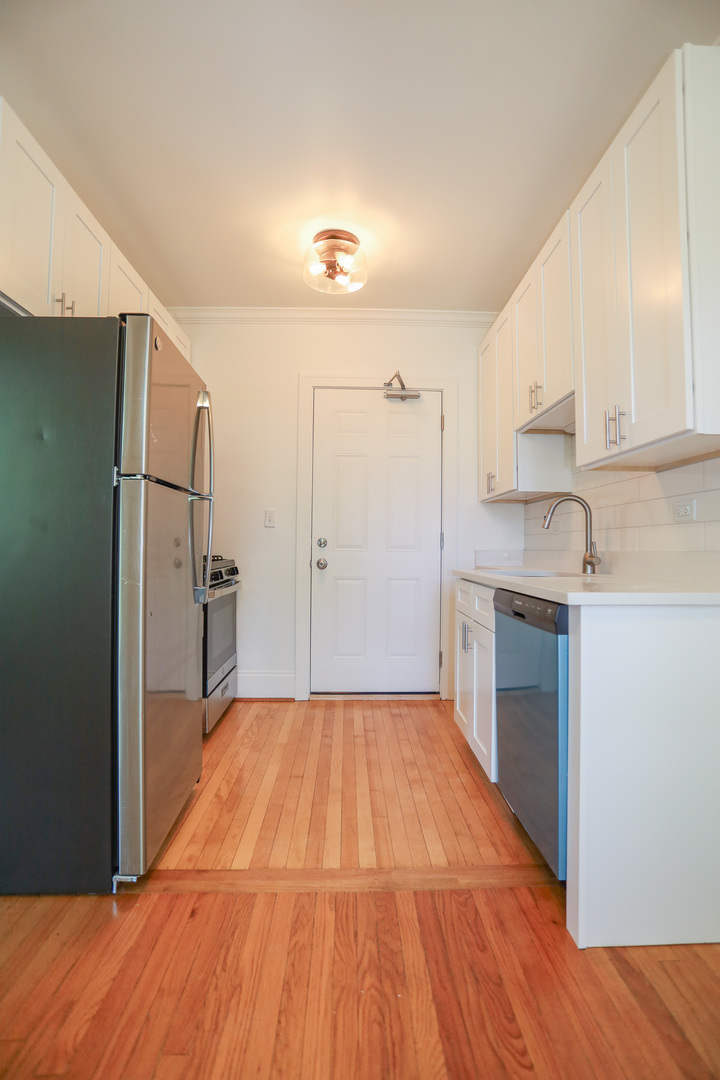 4411 North Hamilton Avenue, Unit 2W Chicago, IL 60618 - Photo 7 of 15 a kitchen with a refrigerator and a stove top oven