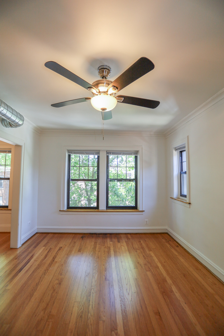 4411 North Hamilton Avenue, Unit 2W Chicago, IL 60618 - Photo 8 of 15 a view of an empty room with wooden floor and a window