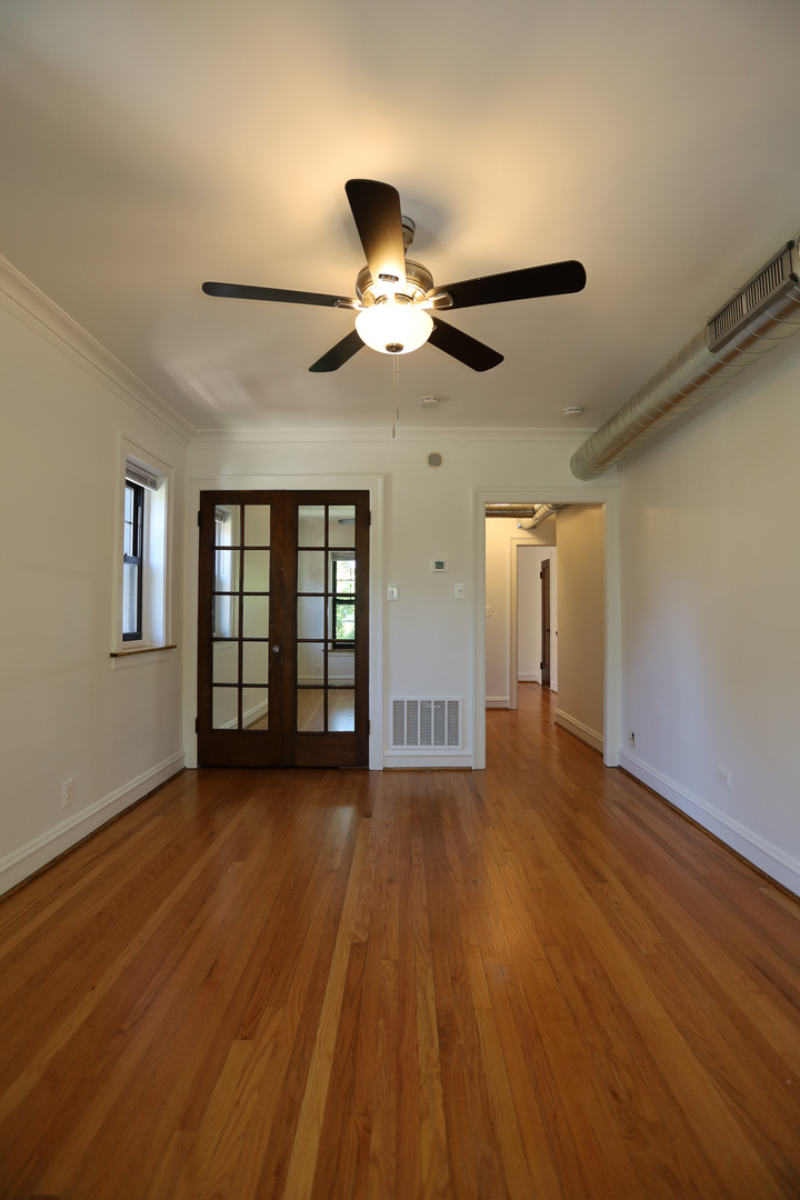 4411 North Hamilton Avenue, Unit 2W Chicago, IL 60618 - Photo 9 of 15 a view of an empty room with wooden floor and a ceiling fan