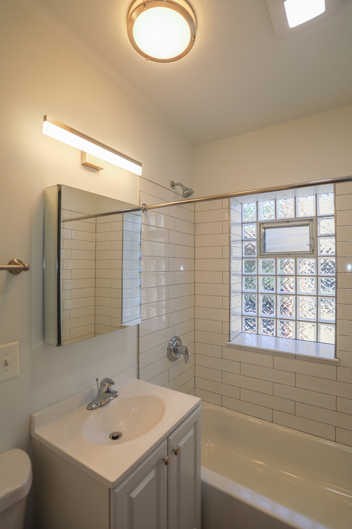 4411 North Hamilton Avenue, Unit 2W Chicago, IL 60618 - Photo 10 of 15 a bathroom with a sink a toilet and shower