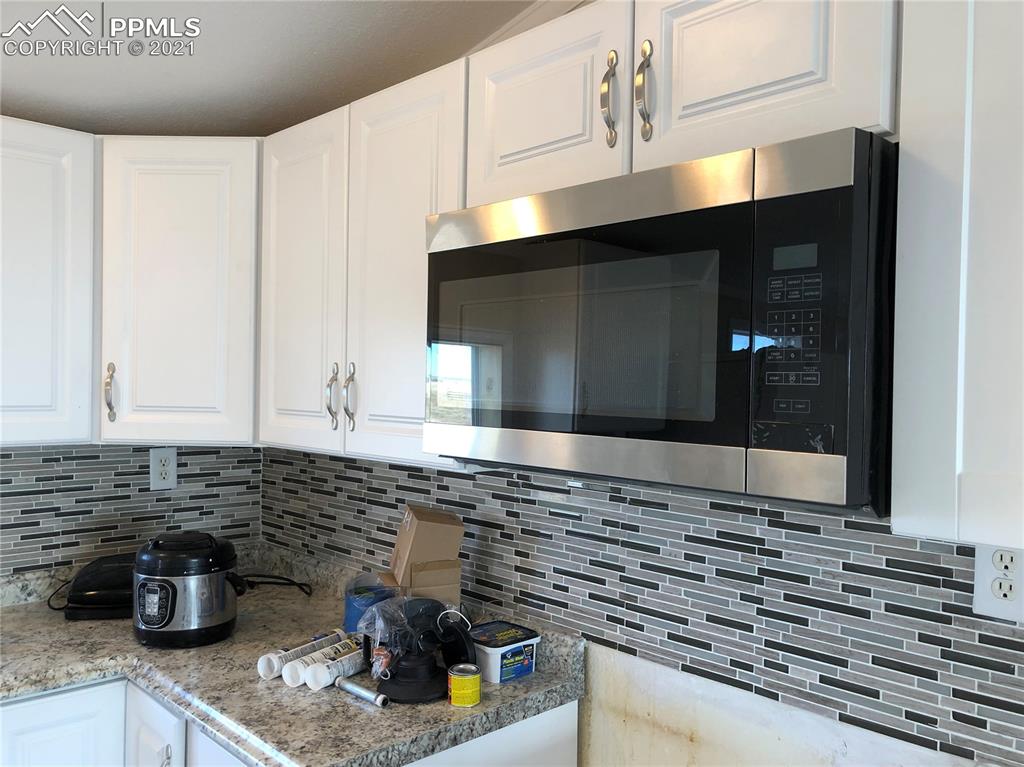 34755 Big Springs Road Yoder, CO 80864 - Photo 12 of 29 a kitchen with a stove and a microwave