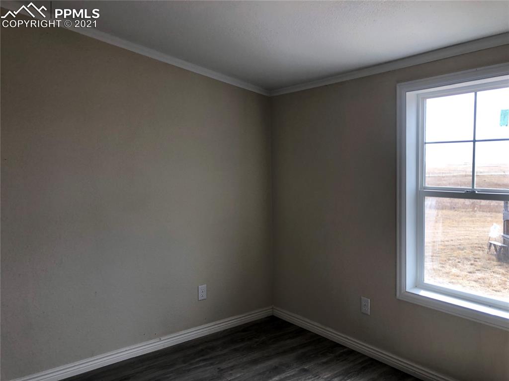 34755 Big Springs Road Yoder, CO 80864 - Photo 18 of 29 an empty room with wooden floor and windows
