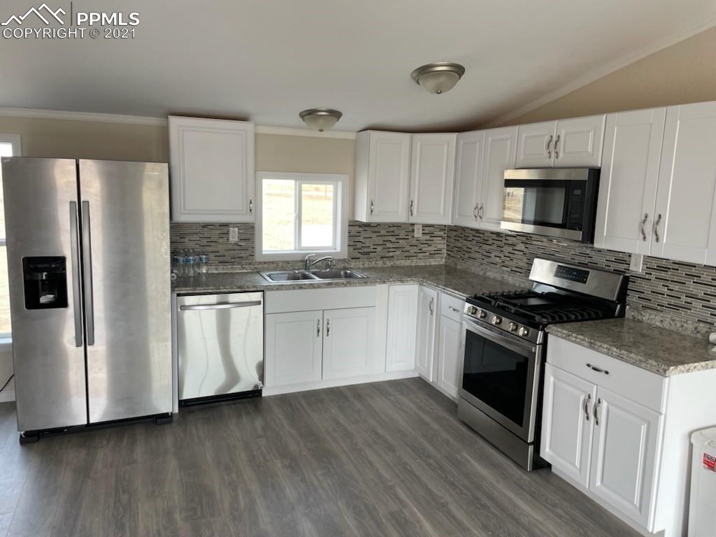 34755 Big Springs Road Yoder, CO 80864 - Photo 8 of 29 a kitchen with granite countertop white cabinets and stainless steel appliances