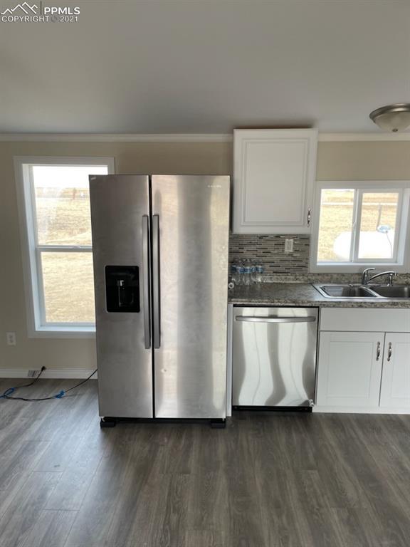 34755 Big Springs Road Yoder, CO 80864 - Photo 9 of 29 a kitchen with stainless steel appliances a refrigerator sink and white cabinets