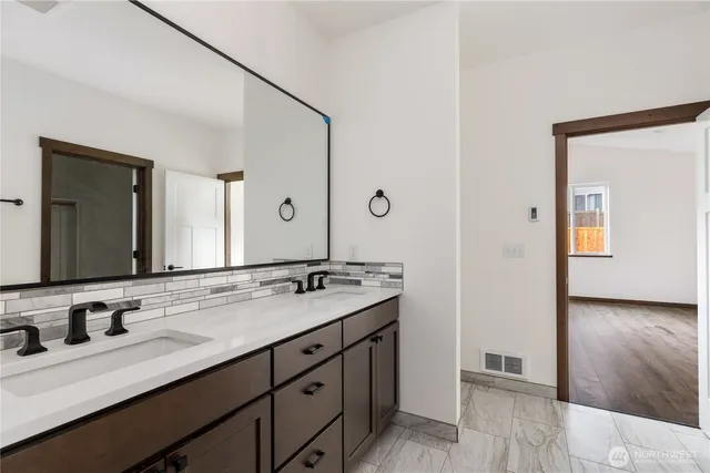 a bathroom with a granite countertop sink double and mirror