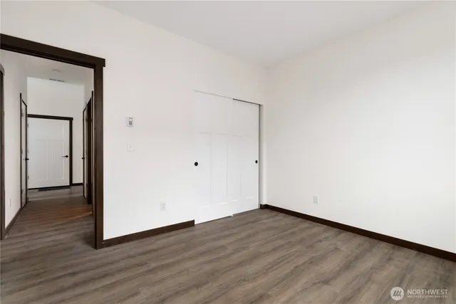 an empty room with wooden floor and mirror