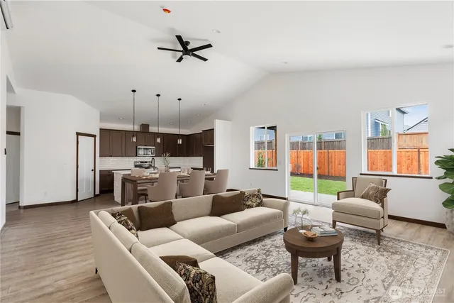 a living room with furniture kitchen view and a large window