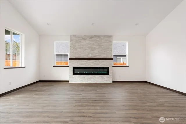 a view of an empty room with a window and fireplace