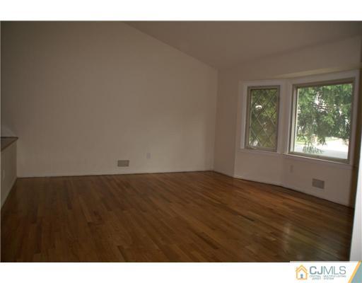 26 Gramercy Road Old Bridge, NJ 08857 - Photo 2 of 14 a view of an empty room with wooden floor and a window