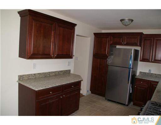 26 Gramercy Road Old Bridge, NJ 08857 - Photo 5 of 14 a kitchen with a refrigerator and cabinets