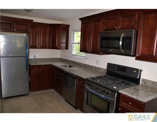 26 Gramercy Road Old Bridge, NJ 08857 - Photo 6 of 14 a kitchen with a stove and a microwave