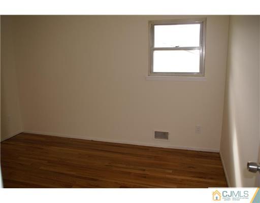 26 Gramercy Road Old Bridge, NJ 08857 - Photo 8 of 14 a view of an empty room with wooden floor and a window