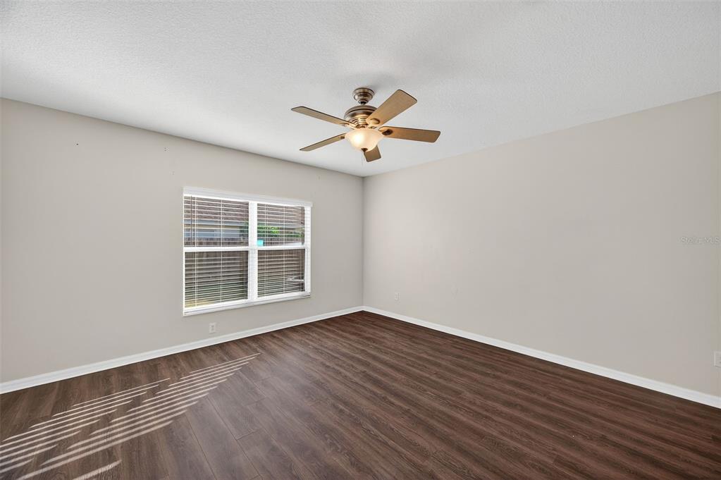 28632 Seashell Court Wesley Chapel, FL 33545 - Photo 14 of 60 a view of an empty room with a window and wooden floor
