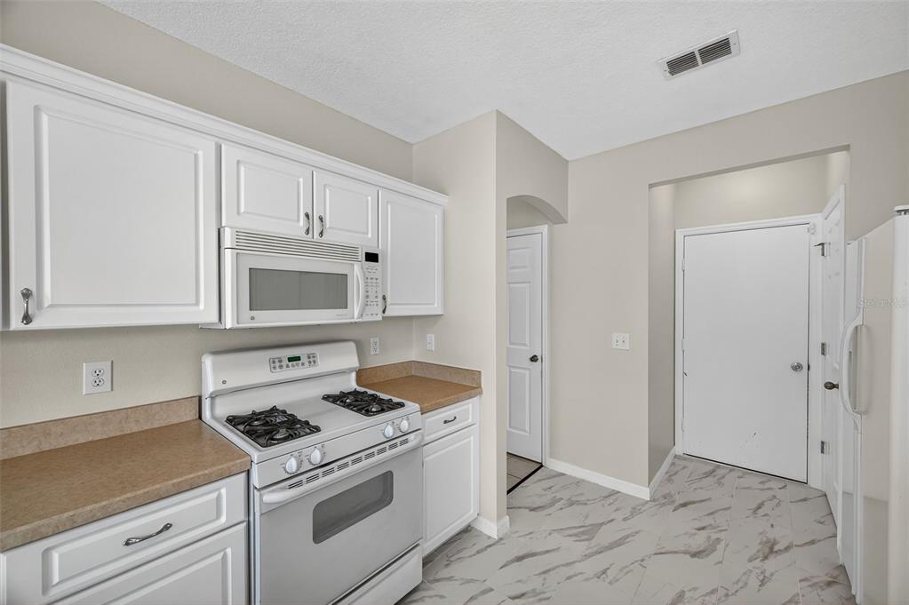 28632 Seashell Court Wesley Chapel, FL 33545 - Photo 22 of 60 a kitchen with white cabinets and white appliances