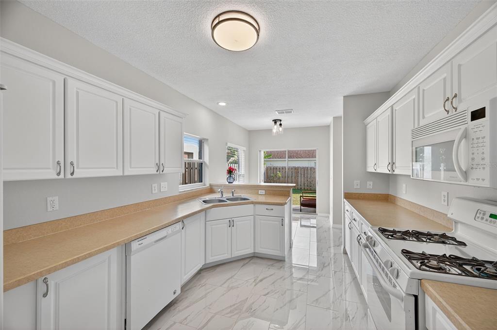 28632 Seashell Court Wesley Chapel, FL 33545 - Photo 23 of 60 a kitchen with a sink stove top oven and cabinets