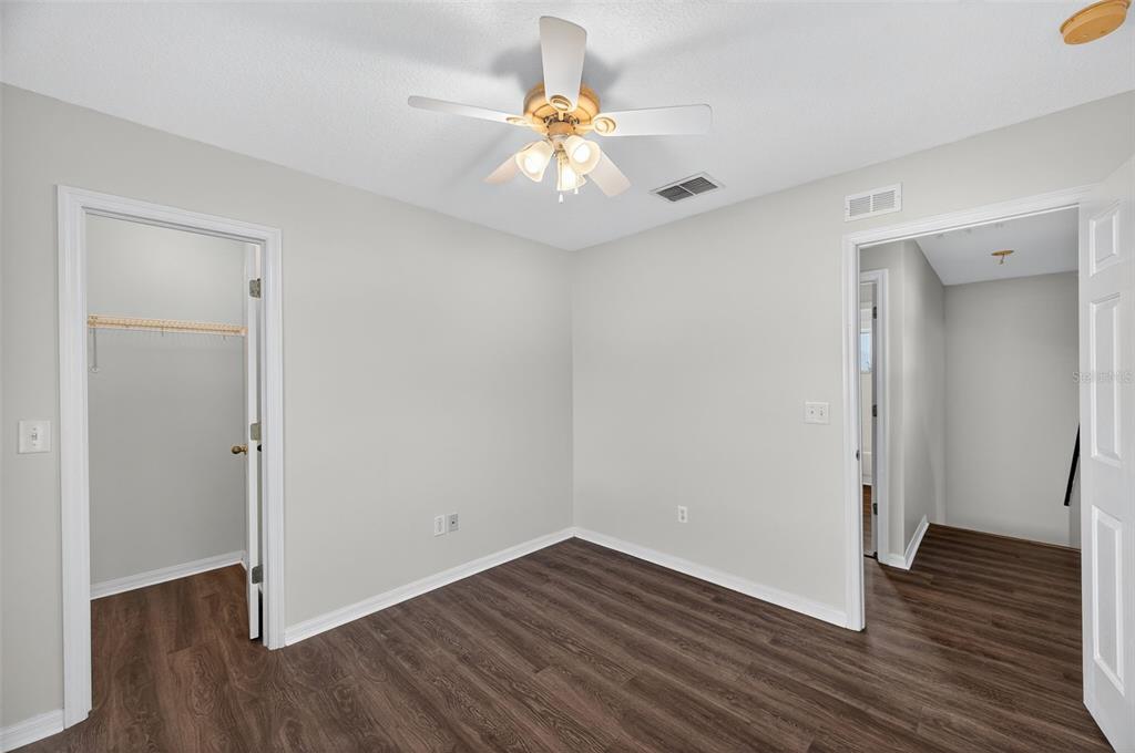 28632 Seashell Court Wesley Chapel, FL 33545 - Photo 30 of 60 an empty room with wooden floor and a ceiling fan
